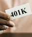 Hand holding piece of paper that says "401k"