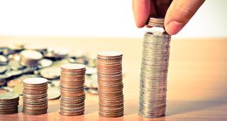 Hand stacking quarters © Singkham/Shutterstock.com