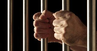 Hands grasping jail bars © angelo gilardelli/Shutterstock.com