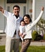 Happy asian family cheering in front of home