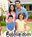 Happy family in front of a yellow house.