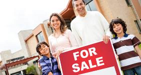 Hispanic family holding for sale sign outside © Andresr/Shutterstock.com