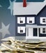 Toy house sitting on a pile of money, with the American flag in the background