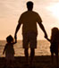 Father with daughters walking on beach