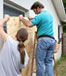 Men putting plywood on window