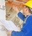 Inspector holding plan checking building © vidguten/Shutterstock.com