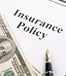 Insurance policy with fountain pen and $100 bills