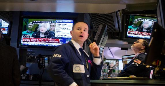The Fed hiked rates again. Here's when you’ll feel it NYSE worker on floor, Janet Yellen on TV behind him | Bloomberg/Getty Images