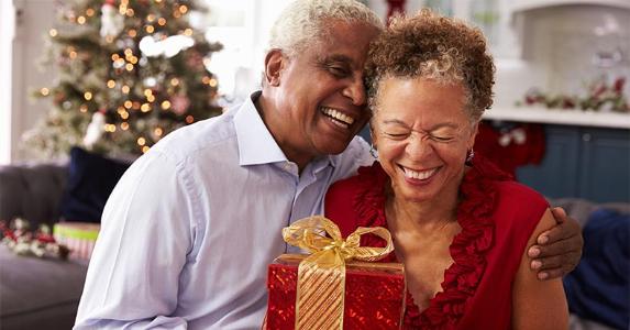 Survey: We love giving gift cards more than getting them Senior couple exchanging Christmas presents | Monkey Business Images/Shutterstock.com