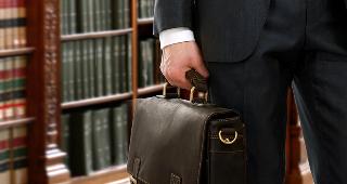 Lawyer holding briefcase in library © sheff/Shutterstock.com