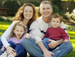 Get into a staycation mindset Family of four sitting on lawn