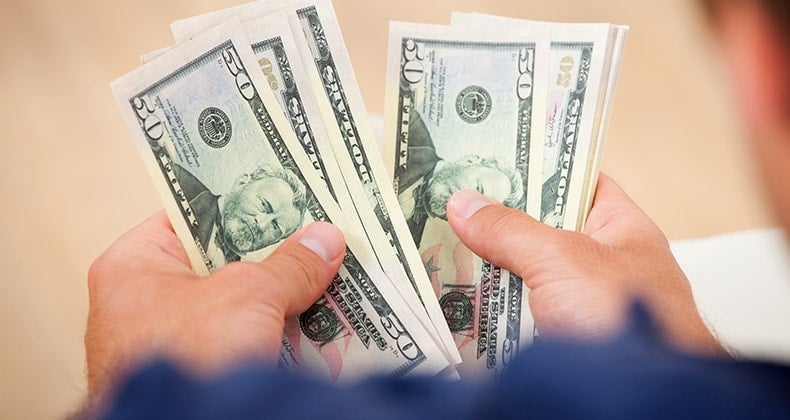 Male counting $50 bills © Andrey_Popov/Shutterstock.com