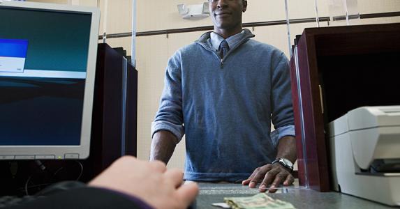 Man depositing money at bank counter