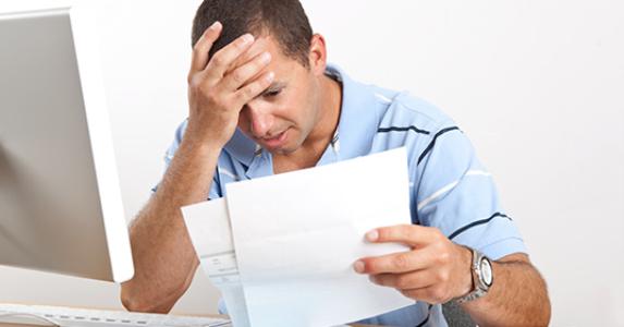 Man on facepalm overwhelmed with bills and paperwork © Barbara Reddoch - Fotolia.com