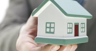 Man holding toy house © Jakub Krechowicz / Fotolia.com