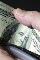 Man holding open wallet with one-hundred dollar bills © ktsdesign/Shutterstock.com