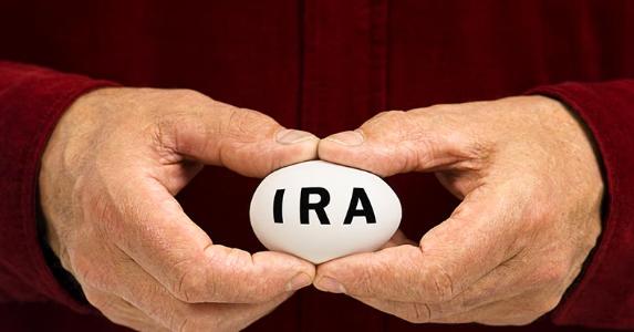 Taking a short-term loan from your IRA Man in red shirt holding IRA egg © Bryan Sikora/Shutterstock.com