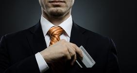 Man in suit putting credit card in pocket © tankist276/Shutterstock.com