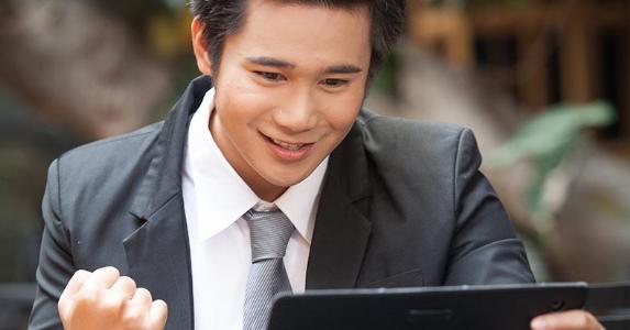 How long does it take to raise your credit score Man excited about content on tablet screen | pan_kung/Shutterstock.com