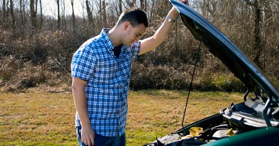 Man looking under the hood of his car © iStock