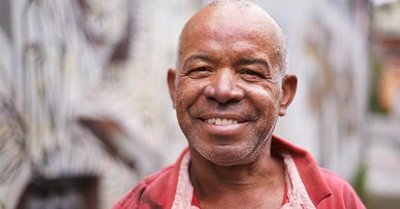 Must I wait 5 years to withdraw Roth IRA earnings? Man standing outside for portrait | PeopleImages/Getty Images