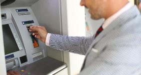 Man withdrawing money from ATM © Goodluz/Shutterstock.com