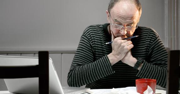How do I pay my $80,000 credit card bill? Man working on finances in his kitchen | iStock.com/Fertnig