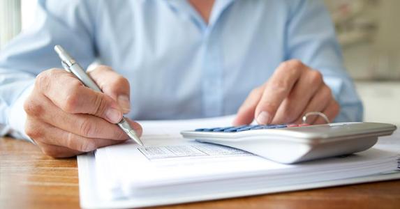What you need to know about gross profit margin Man doing calculations on paper | dagmar heymans/Getty Images