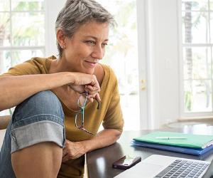 Woman working on laptop at home | Kevin Dodge/Getty Images
