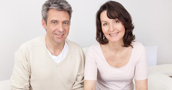 Middle aged couple reviewing documents on couch © Andrey_Popov/Shutterstock.com