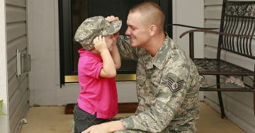 Military father putting hat on his child | JaniceRichard/E+/Getty Images
