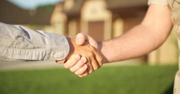 Military men shaking hands outside home | Veterans United