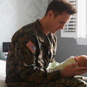 Military father holding his newborn baby | LWA/Dann Tardif/Getty Images