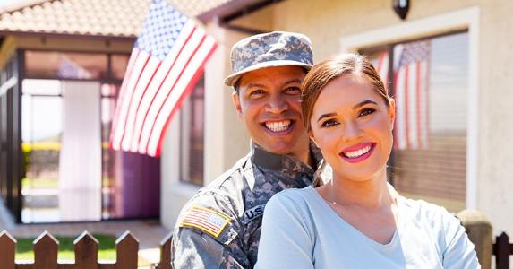Can veteran get a tax break on a short sale? Military man and wife standing outside house | michaeljung/Shutterstock.com