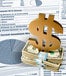 A large gold dollar sign on top of a stack of money and a bank statement in the background