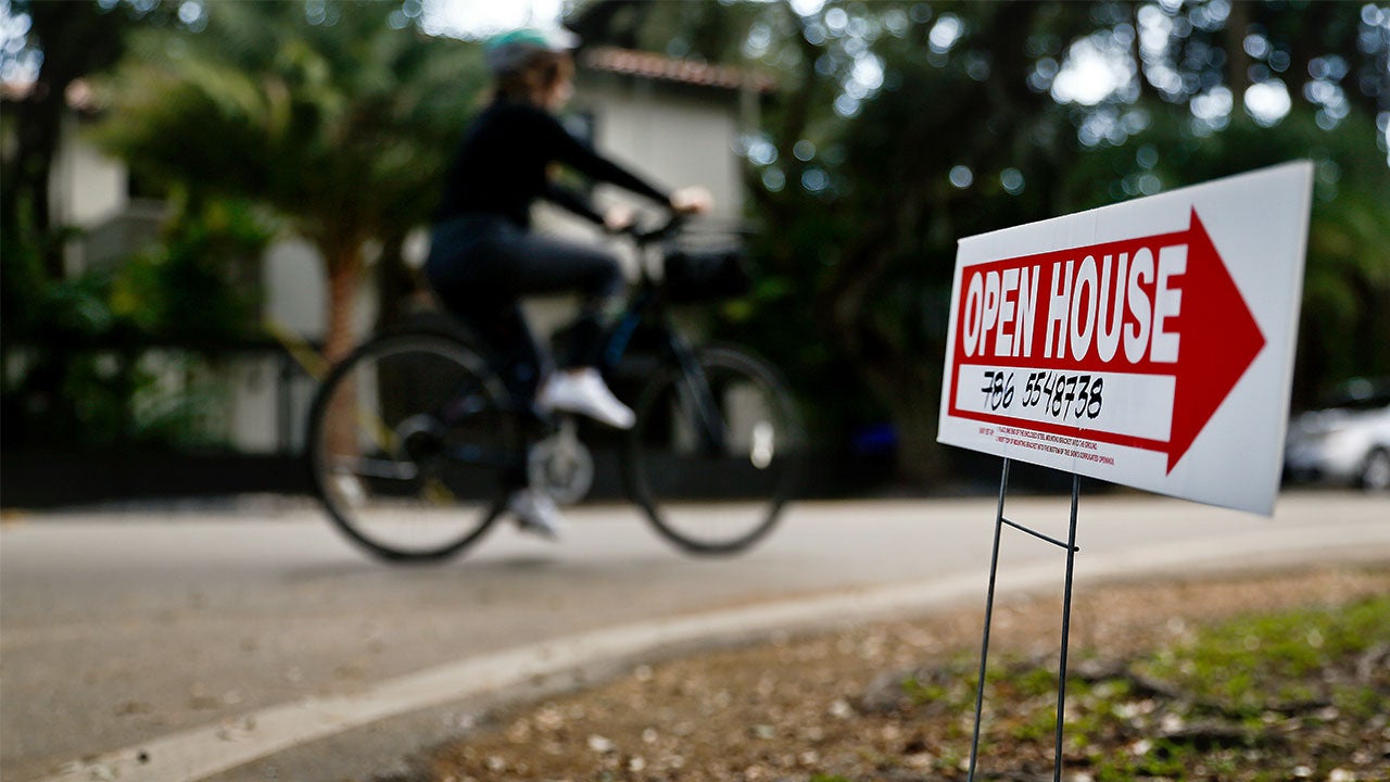 Mortgage rates dip again, though rising home prices are crashing the party Person biking away from open house sign | Bloomberg/Getty Images