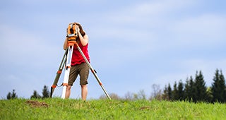 Woman surveying empty lot © l i g h t p o e t/Shutterstock.com