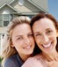 mother and daughter smiling in front of house