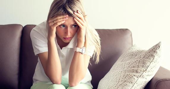 Nervous woman sitting on a couch © iStock