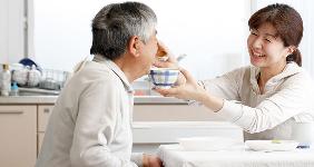 Nurse feeding older man at retirement home © kazoka/shutterstock.com