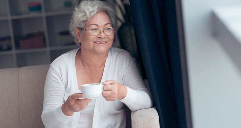 Nonborrower spouses get reverse-mortgage relief Woman enjoying a coffee by her window | iStock.com/DragonImages