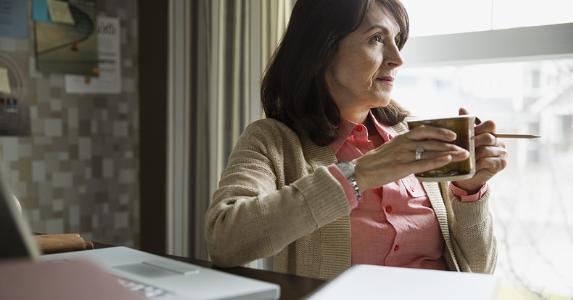 title here Older woman holding coffee mug | Hero Images/Getty Images