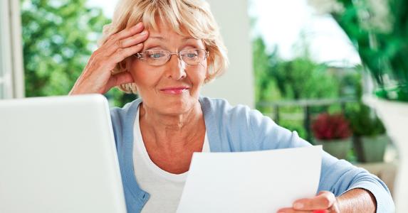 Woman looking unhappily at her bill © iStock