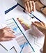 people's hands analyzing charts