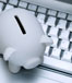 White piggy bank standing on silver keyboard, top view