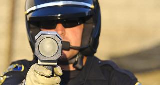 Police officer aiming radar gun © John Roman Images/Shutterstock.com