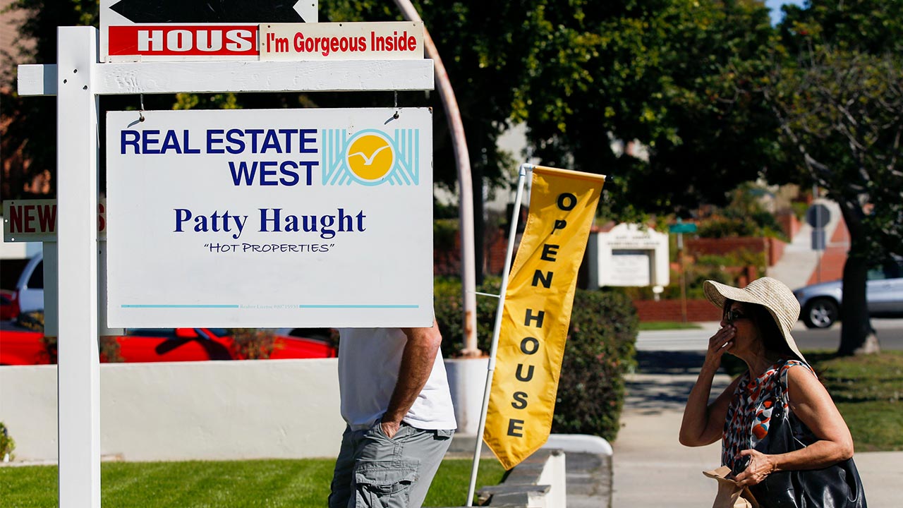 Mortgage rates remain at attractive, 7-month lows People walking into open house | Bloomberg/Getty Images