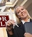 Real estate agent holding keys for sale sign ? Andy Dean Photography/Shutterstock.com