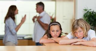 Sad children with parents fighting in background © wavebreakmedia/Shutterstock.com