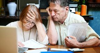 Senior couple with bills © CREATISTA/Shutterstock.com